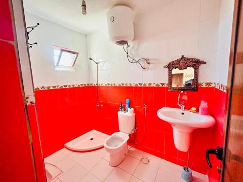 杰拉什apartment between ajloun castle and Jerash ruins的红色的浴室设有卫生间和水槽