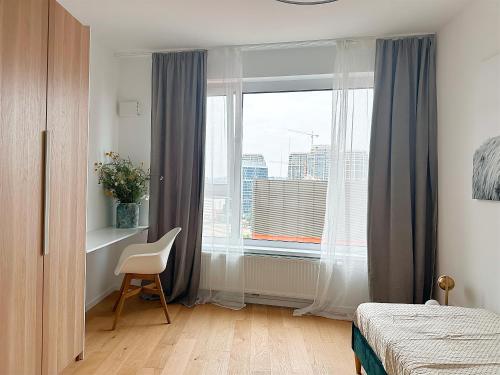 布拉迪斯拉发Luxurious brand new FREE parking apartment的卧室设有窗户、椅子和床