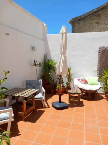 奥德米拉Casa da Umbria的庭院配有桌子、遮阳伞和椅子