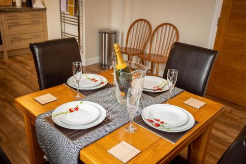 马特洛克Swallow View, A Spacious Base with stunning views的餐桌,配有一瓶葡萄酒和玻璃杯