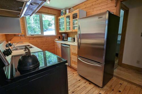 北湾Cozy Cabin on Trout Lake的厨房配有不锈钢冰箱和水槽