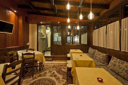 卡拉维塔Fanaras Hotel的一间带桌椅的餐厅以及一间配有桌子的房间