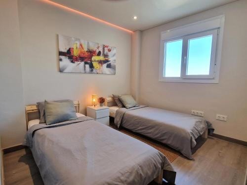 贝纳尔马德纳Emerald Apartment - Spacious Modern 2 Bedroom的一间卧室设有两张床和窗户。