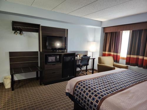 斯蒂尔沃特Stillwater Inn & Suites的配有一张床和一台平面电视的酒店客房