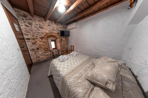 Casa Rural El Palomeque的一间卧室设有一张床和石墙