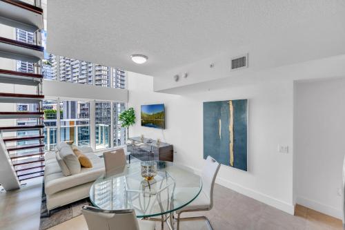 迈阿密Stunning 1 Bedroom Loft in The Heart of Brickell的客厅配有玻璃桌和沙发