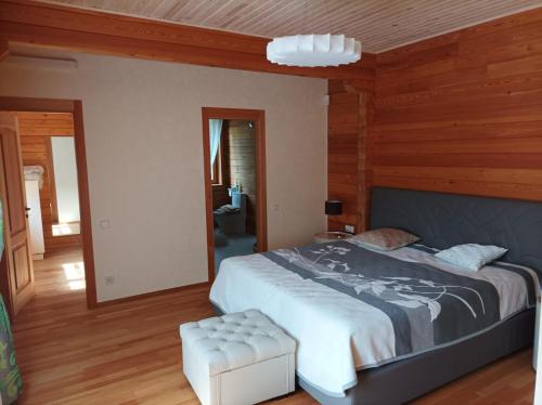 PriežmaleJaunakmeņi的一间卧室设有一张大床和木墙