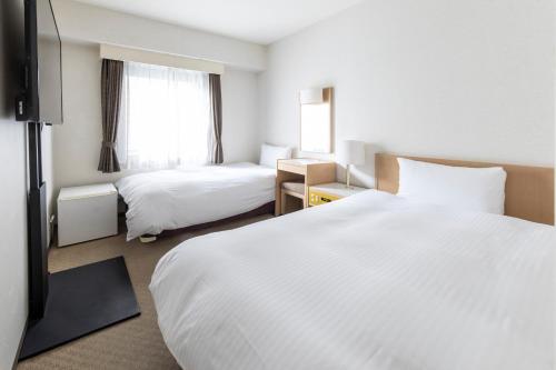 新泻科特新泻酒店的酒店客房设有两张床和窗户。