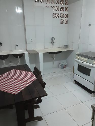 瓜拉派瑞VERDEPERTO Camping Clube的白色的厨房配有桌子和炉灶。