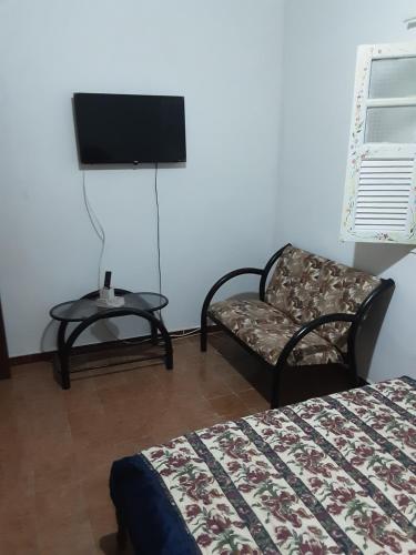 瓜拉派瑞VERDEPERTO Camping Clube的一间卧室配有一张床、一把椅子和电视。