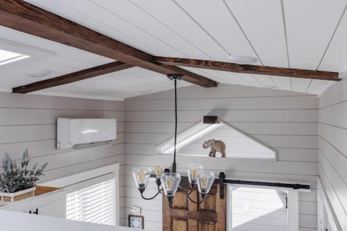 Apple ValleyRoyal sands tiny home的厨房拥有白色的墙壁和带吊灯的天花板。