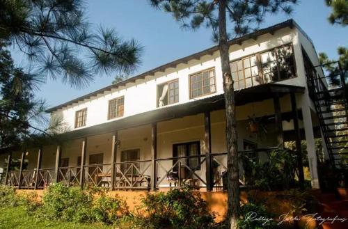 Villa LoncaLa Laurina Casa de Campo Hotel/Hospedaje的一座大型白色建筑,设有阳台和树木