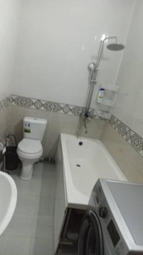 费尔干纳Apartment.1的白色的浴室设有卫生间和水槽。