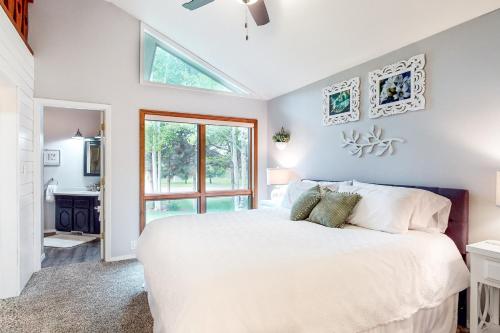 Apple Cottage的卧室配有白色的床和窗户。