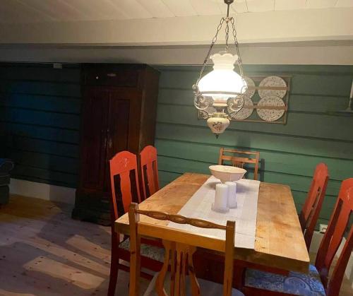 莫尔德Draget gård的一间带木桌和吊灯的用餐室