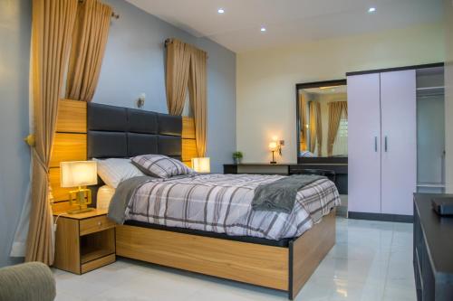 伊巴丹Lake Luxury Homes的一间卧室配有一张床、一张书桌和一面镜子