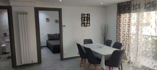 Ouled MoussaAppartement F3 moderne en Résidence的一间配备有白色桌椅的用餐室