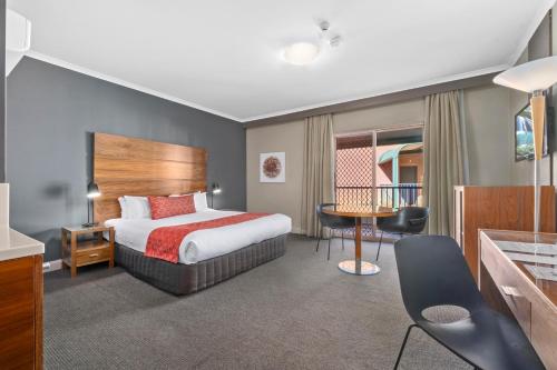 堪培拉迪克森品质酒店的酒店客房配有一张床铺和一张桌子。