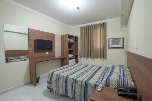 瓜鲁雅Hotel Guarumar Gold的酒店客房,配有床和电视