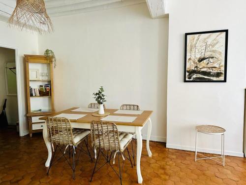 索恩河畔沙隆"Douceur de vignes", cosy, coeur de ville, Classé 3 étoiles - BY PRIMO C0NCIERGERIE的一间带木桌和椅子的用餐室