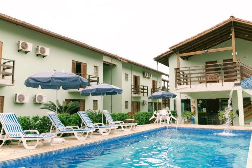 马利西亚斯Hotel Kiribati Maresias的酒店设有带椅子和遮阳伞的游泳池