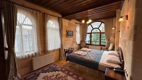 于尔居普Akuzun Stone Hotel的一间设有床铺的卧室,位于带窗户的房间内