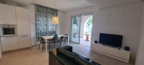 马斯卡利Villa sul mare Dambra Apartment的带沙发、电视和桌子的客厅