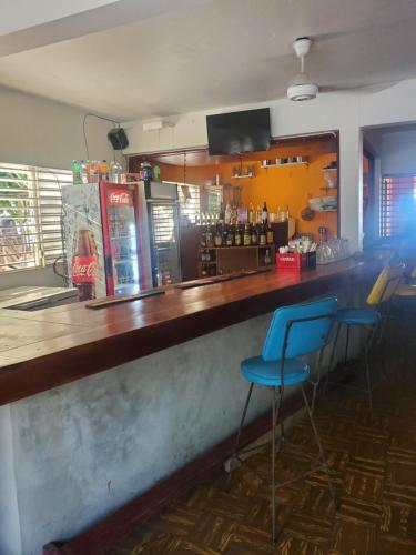 蒙特哥贝Evelin's On The Beach的一间酒吧,在一间房间里设有两个蓝色凳子