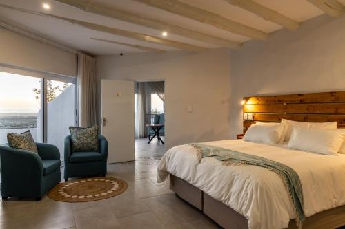 CrawleyCapri Sands Luxury Guest House的一间卧室配有一张大床和两把椅子