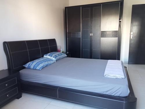 特马拉Maison indépendante 100m2 à Témara centre的一间卧室配有一张带黑色床头板的床