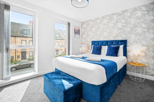 伯明翰Luxury 4 Bed House with En-suite, Games room, BBQ, On-site parking By Azura Nights的卧室配有蓝色和白色的床和窗户。