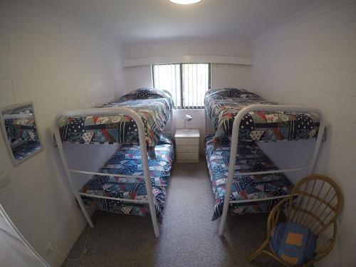 布鲁斯海滩Blueys Beach Villa Manyana 14的小房间设有两张双层床和窗户
