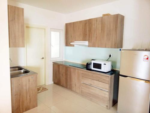 吉隆坡Comfy+ by ARH KLCC的厨房配有冰箱和微波炉。