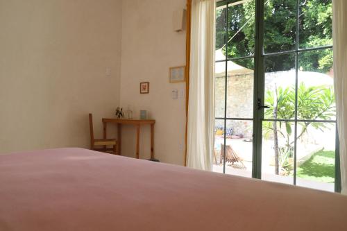 梅里达Nuik Casa Tropical的一间卧室设有一张床和一个大窗户