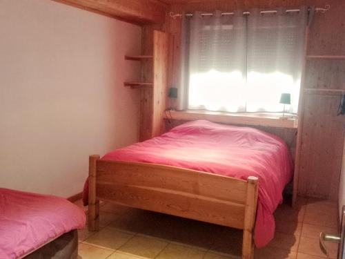 蒙乃第耶-勒潘Chalet Le Monêtier-les-Bains, 6 pièces, 8 personnes - FR-1-762-30的一间卧室配有一张带粉色床单的床和一扇窗户。