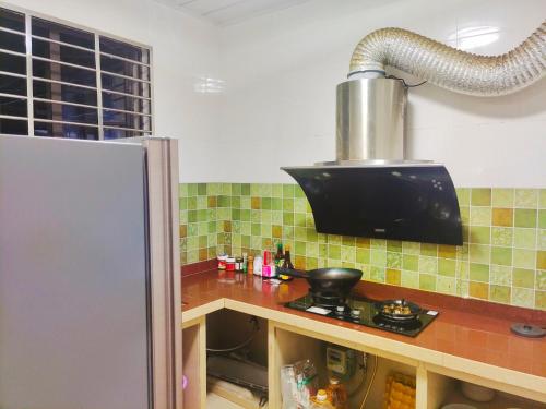 三亚闲肆民宿的厨房配有台面和冰箱