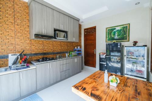 塞米亚克Wayan House Seminyak的厨房配有木桌和冰箱。