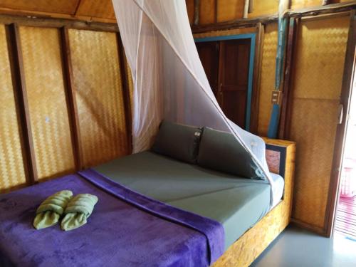 高兰安达曼湾简易别墅的配有蚊帐的客房内的一张床位