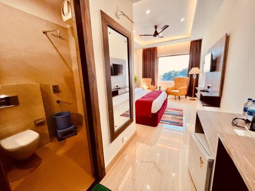瑞诗凯诗Ganges Blossam, Haridwar-Rishikesh Road - A Four Star Luxury Hotel的一间酒店客房 - 带一张床和一间浴室