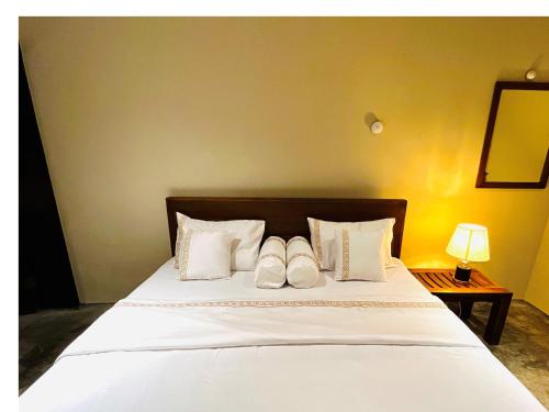 尼甘布Ceylon Kingsmen Garden Hotel - Katunayake的一间卧室配有一张带两个白色枕头的床