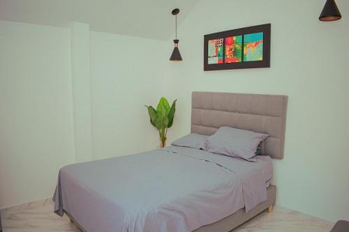 圣贝尔纳多德尔比恩托Cabañas Mambo Beach的卧室配有白色的床,上面有植物
