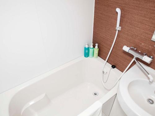 沼田Hotel Route Inn Numata的浴室配有白色浴缸和水槽