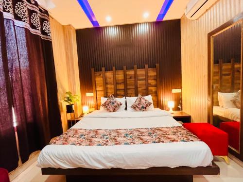钱德加尔Hotel Pearl Grand, Zirakpur - Top Rated & Most Awarded Property in Tricity的一间卧室配有一张大床和一张红色椅子