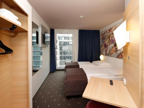 柏林B&B HOTEL Berlin-Alexanderplatz的酒店客房设有两张床和窗户。