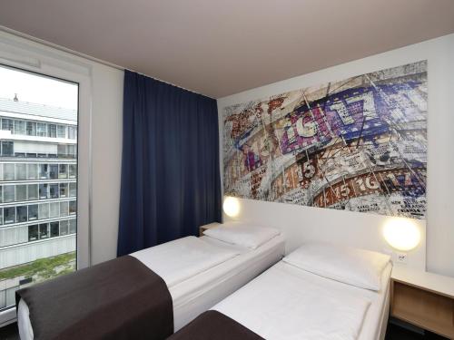 柏林B&B HOTEL Berlin-Alexanderplatz的客房设有两张床和壁画墙