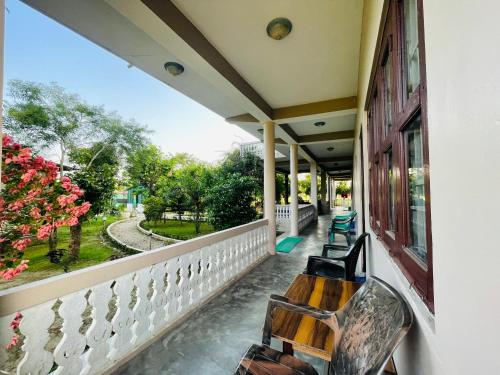 奇旺Hotel Tree Tops- A Serene Friendly Hotel in Sauraha的一个带长凳并享有公园景色的门廊