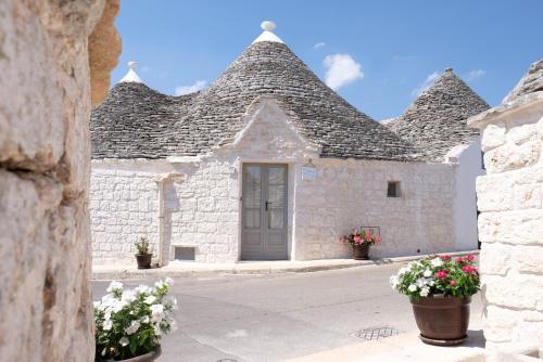 阿尔贝罗贝洛Trulli Soave的白色的石头建筑,花草覆盖的灰色屋顶