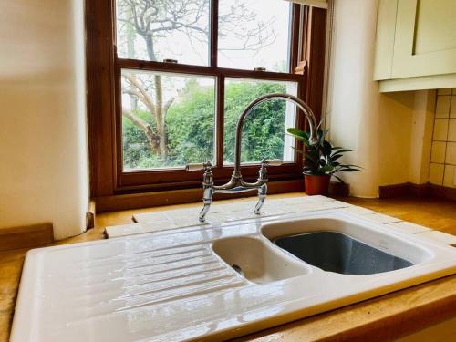 奇平诺顿Cotswold Home over 4 floors - perfect for Families Friends Contractors的带窗户的厨房内的白色水槽