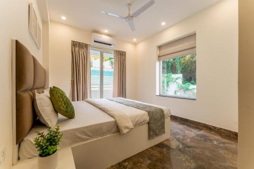 莫尔穆冈Lavish Apartments with Swimming Pool near Candolim Beach的一间卧室设有一张床和一个窗口