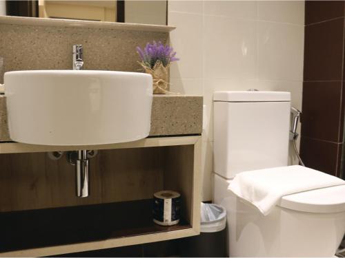 新加坡Aqueen Prestige Hotel Lavender的浴室配有白色卫生间和盥洗盆。